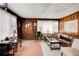 Living room with wood-paneled walls, mixed flooring, and a worn leather couch at 2293 Ewing Sw St, Atlanta, GA 30331