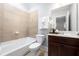 Tiled bathroom features a tub, toilet, vanity with mirror, and decorative elements at 2548 Crescent Park Ct # 7, Atlanta, GA 30339