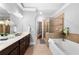 Bright bathroom featuring double vanity, soaking tub with tiled surround, and glass-enclosed shower at 2548 Crescent Park Ct # 7, Atlanta, GA 30339