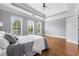 Bright main bedroom with a tray ceiling, hardwood floors, and a view of the surrounding trees at 2548 Crescent Park Ct # 7, Atlanta, GA 30339