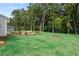 Expansive backyard with a cozy fire pit area, lush green lawn, and privacy provided by mature trees at 410 Beacon Way Way, Villa Rica, GA 30180