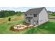 View of backyard with stone fire pit surrounded by lush landscape at 410 Beacon Way Way, Villa Rica, GA 30180