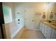 Bright bathroom with tub, window, and white vanity with granite counters at 8145 Lakeview Pkwy, Villa Rica, GA 30180