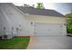Spacious two-car garage with white doors, exterior lighting, and a paved driveway at 8145 Lakeview Pkwy, Villa Rica, GA 30180