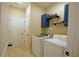 Convenient laundry room with modern machines, overhead storage, and stylish wallpaper accent wall at 8145 Lakeview Pkwy, Villa Rica, GA 30180