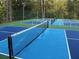 Overhead view of multi-colored pickleball courts with green forest backdrop at 8145 Lakeview Pkwy, Villa Rica, GA 30180