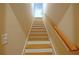 A carpeted staircase with a wooden railing and white risers at 8145 Lakeview Pkwy, Villa Rica, GA 30180