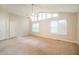 Spacious living room featuring high ceilings, large windows, and neutral carpet at 8607 Wood Springs Ct, Douglasville, GA 30135
