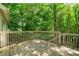 Exterior of the wood back deck surrounded by lush green trees providing shade at 503 Fable Ln, Canton, GA 30114