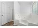 Spacious bathroom featuring a large tub, glass-enclosed shower, and a window at 503 Fable Ln, Canton, GA 30114