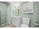 Bathroom with a light green wall, cabinet with a mirror, toilet, and shelving unit at 503 Fable Ln, Canton, GA 30114