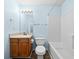 Bathroom with blue walls, a combined shower-tub, and wooden cabinets at 503 Fable Ln, Canton, GA 30114