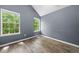 Bedroom featuring wood floors, two windows with outdoor views, and gray colored walls at 503 Fable Ln, Canton, GA 30114