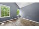 Bedroom with wood-look flooring, gray walls, and two large windows at 503 Fable Ln, Canton, GA 30114
