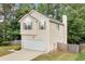 View of the home's vinyl siding, chimney, and attached garage nestled on a wooded lot at 503 Fable Ln, Canton, GA 30114