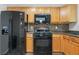A well-equipped kitchen featuring black appliances and wooden cabinets at 503 Fable Ln, Canton, GA 30114