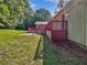 Side view of the backyard with a red painted deck and lawn, with wooded background at 5142 Golfbrook Ct, Stone Mountain, GA 30088