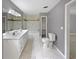 Stylish bathroom featuring double vanity, white tile, a toilet and an enclosed bathtub at 5142 Golfbrook Ct, Stone Mountain, GA 30088