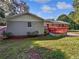 View of a home's backyard featuring a red painted deck and lush green lawn at 5142 Golfbrook Ct, Stone Mountain, GA 30088