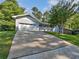 Inviting home exterior with a long driveway, garage, quaint porch and lush green lawn at 5142 Golfbrook Ct, Stone Mountain, GA 30088