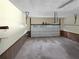 Spacious garage featuring overhead storage and a roll-up door at 5142 Golfbrook Ct, Stone Mountain, GA 30088