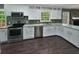 Well-lit kitchen features white cabinets, granite countertops, stainless steel appliances, and stone backsplash at 5142 Golfbrook Ct, Stone Mountain, GA 30088