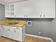 Functional laundry room with sink, countertop, and ample cabinetry for storage and organization at 5142 Golfbrook Ct, Stone Mountain, GA 30088