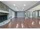 Expansive living room featuring a stone fireplace, built-in shelving, and hardwood floors at 5142 Golfbrook Ct, Stone Mountain, GA 30088