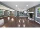 Open-concept living space featuring wood floors, recessed lighting, kitchen access, and stone fireplace at 5142 Golfbrook Ct, Stone Mountain, GA 30088