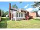 The backyard of this home features a sunroom with lots of windows and a wooden deck with stairs leading down at 5633 Southland Dr, Stone Mountain, GA 30087