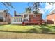 A lush backyard features a brick home with a sunroom and a wood deck, offering outdoor living and entertaining space at 5633 Southland Dr, Stone Mountain, GA 30087