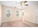 Bedroom with neutral carpet, windows with blinds, ceiling fan, and access to a bathroom at 5633 Southland Dr, Stone Mountain, GA 30087