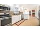 Modern kitchen featuring stainless steel appliances, granite countertops, and tiled flooring with open access to the dining room at 5633 Southland Dr, Stone Mountain, GA 30087