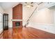 Spacious living room featuring a brick fireplace, hardwood floors, and a staircase that goes to the second floor at 5633 Southland Dr, Stone Mountain, GA 30087