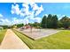 Community playground with modern equipment, swings and slide surrounded by green space, trees and walking path at 5633 Southland Dr, Stone Mountain, GA 30087