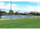 Community tennis court with a well-maintained blue surface, enclosed by a black fence, and surrounded by green grass at 5633 Southland Dr, Stone Mountain, GA 30087