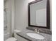 Bathroom featuring a granite countertop, decorative mirror, and a shower-tub combo at 7570 Rambling Vale, Cumming, GA 30028