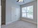 Neutral bedroom featuring a window, closet, and carpeted floor at 7570 Rambling Vale, Cumming, GA 30028