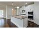 Kitchen island with granite countertop, white cabinets, and stainless steel appliances at 7570 Rambling Vale, Cumming, GA 30028