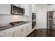 Kitchen featuring white cabinets, stainless steel appliances, and tile backsplash at 7570 Rambling Vale, Cumming, GA 30028
