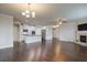 Open floor plan showing kitchen with white cabinets adjacent to a living room with fireplace and hardwood floors at 7570 Rambling Vale, Cumming, GA 30028