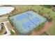 Aerial view of community tennis courts with lighting for evening play, surrounded by landscaped grounds at 7570 Rambling Vale, Cumming, GA 30028