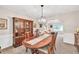 Well-lit dining room with hardwood table, glass display cabinet, and views into the living room at 2101 Emerald Dr, Loganville, GA 30052