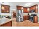 Modern kitchen with stainless steel appliances, rich wood cabinetry, and views into the adjacent dining area at 2101 Emerald Dr, Loganville, GA 30052