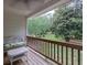 Relaxing porch featuring a cozy wicker chair with views of the green, landscaped backyard at 2101 Emerald Dr, Loganville, GA 30052