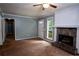 A spacious living room featuring a stone fireplace, neutral walls, and carpet flooring at 3963 Ferncliff Rd, Snellville, GA 30039