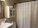 Modest bathroom featuring a white vanity, medicine cabinet, and a patterned shower curtain at 2523 Bronco Trl, Duluth, GA 30096