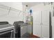 This laundry room features a front load washer and dryer, storage cabinets, and metal storage racks at 3334 Peachtree Ne Rd # 1609, Atlanta, GA 30326