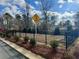 Community playground area with sign, black metal fence and mulch with evergreens against natural wooded area at 5002 Elowen Ln, Douglasville, GA 30135