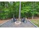 Cozy backyard fire pit area with seating, nestled among mature trees and lush greenery for private outdoor enjoyment at 620 Alcovy Springs Dr, Lawrenceville, GA 30045